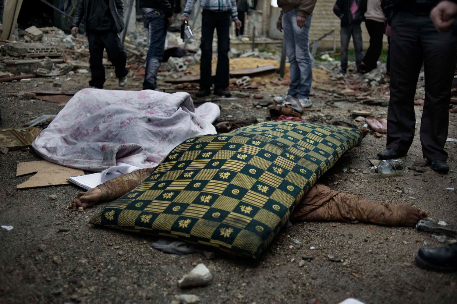 Feb. 10, 2012. The body of a Syrian police member lies on the ground in front of the former police station in al-Qsair. Eleven members of the Syrian police were killed.