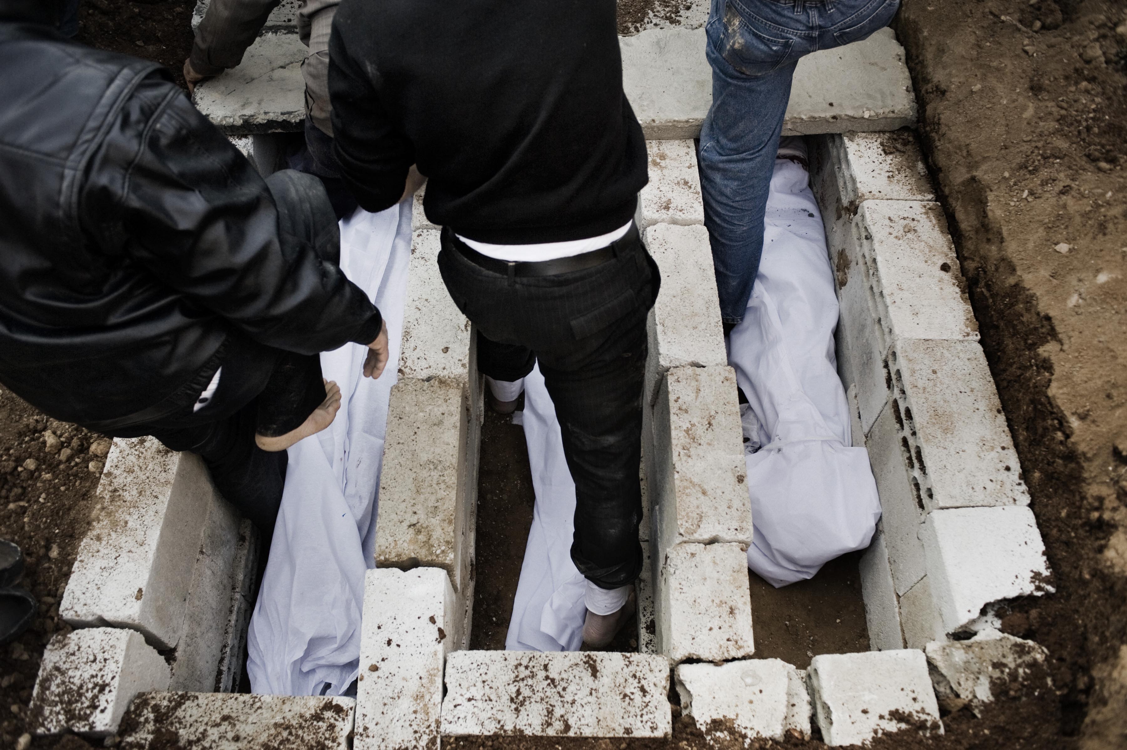 Feb. 20, 2012. Men prepare the graves of three shaheed (martyrs) killed by a mortar attack launched by Al Assad forces, among them two children, in Homs Province.