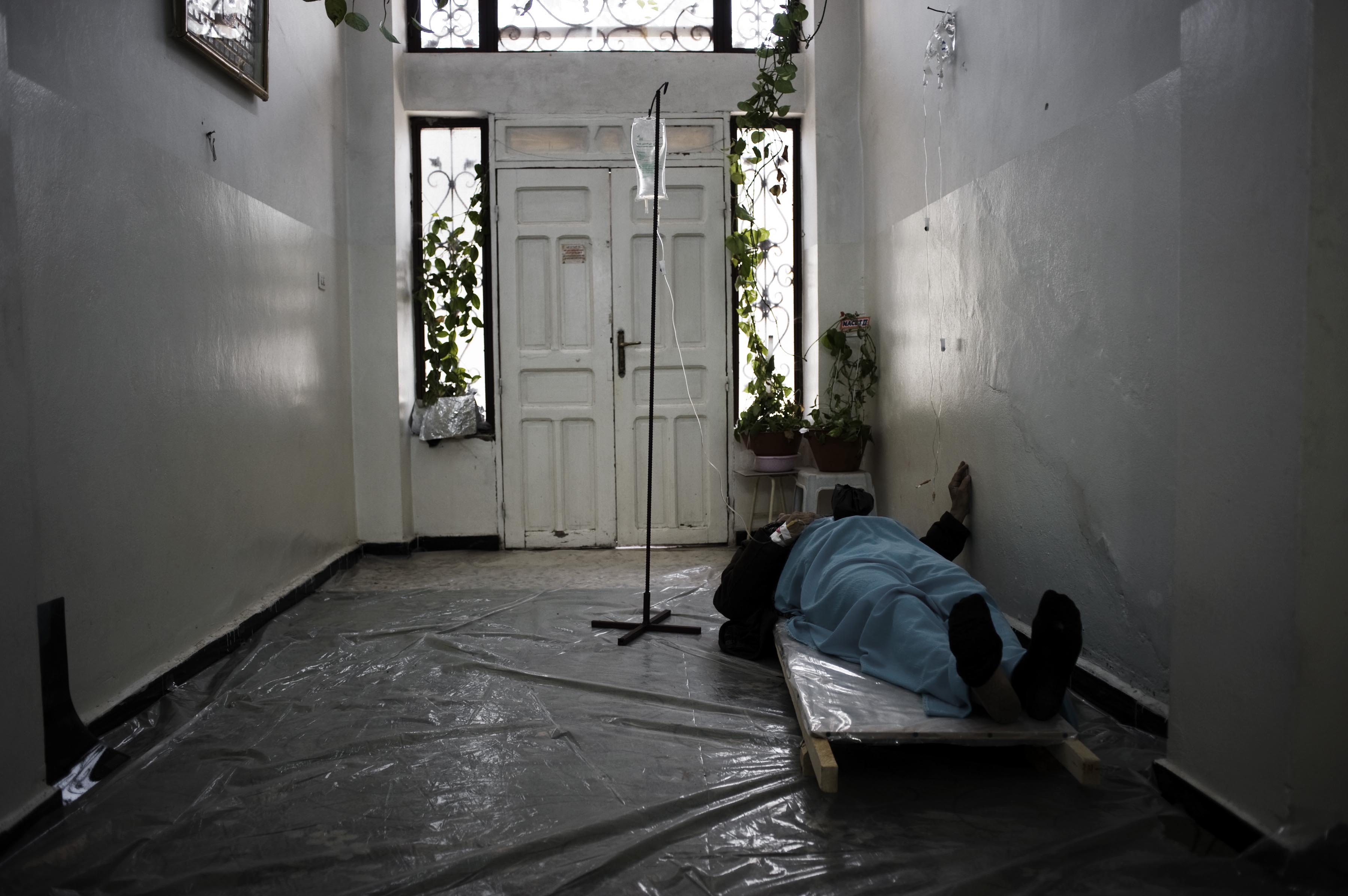 Feb. 22, 2012. A patient lies down in the entrance of a house used as a hospital in Homs Province.