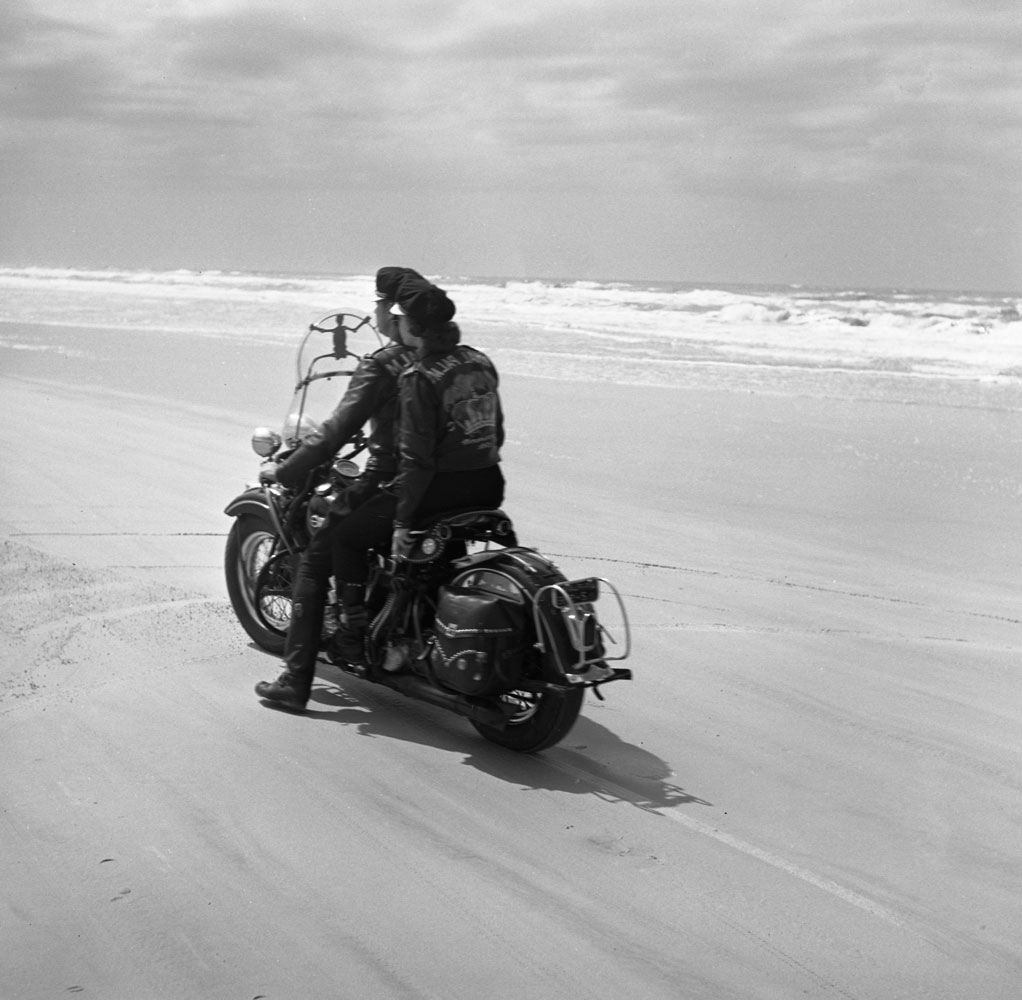 Two members of a motorcycle club drive on a cycle on the beach during the Daytona 200 motorcycle race, Daytona Beach, Florida, March 1948.