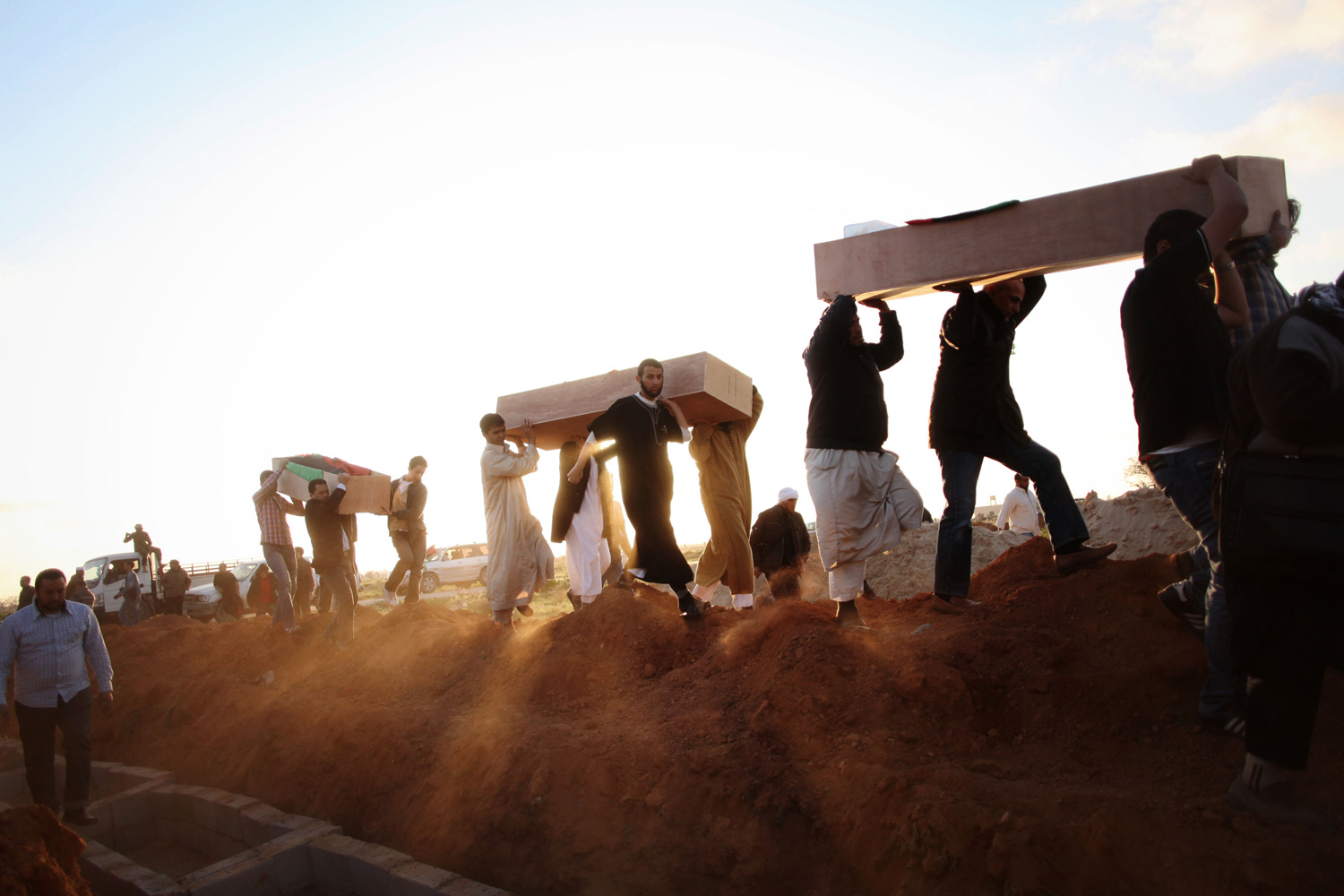 March 5, 2012. Libyan men carry coffins of victims, discovered in a mass grave, at a funeral in Benghazi, Libya.
