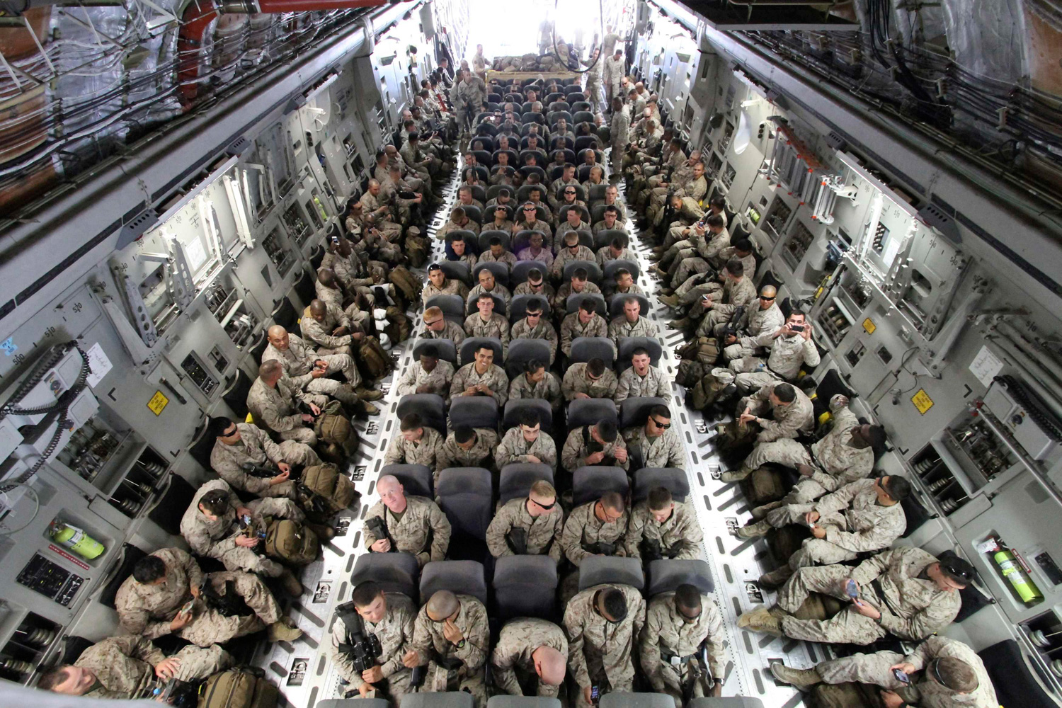March 27, 2012. U.S. servicemen sit after boarding a transport plane before leaving for Afghanistan at the U.S. transit center at Manas airport near Bishkek, Kyrgyzstan.