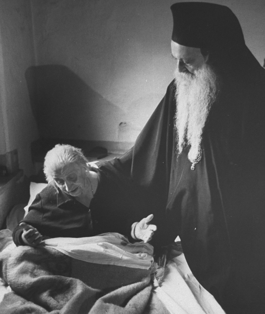 Patriarch Athenagoras I, Archbishop of Constantinople (Istanbul), Eastern Orthodox, visits a sick member of the church.