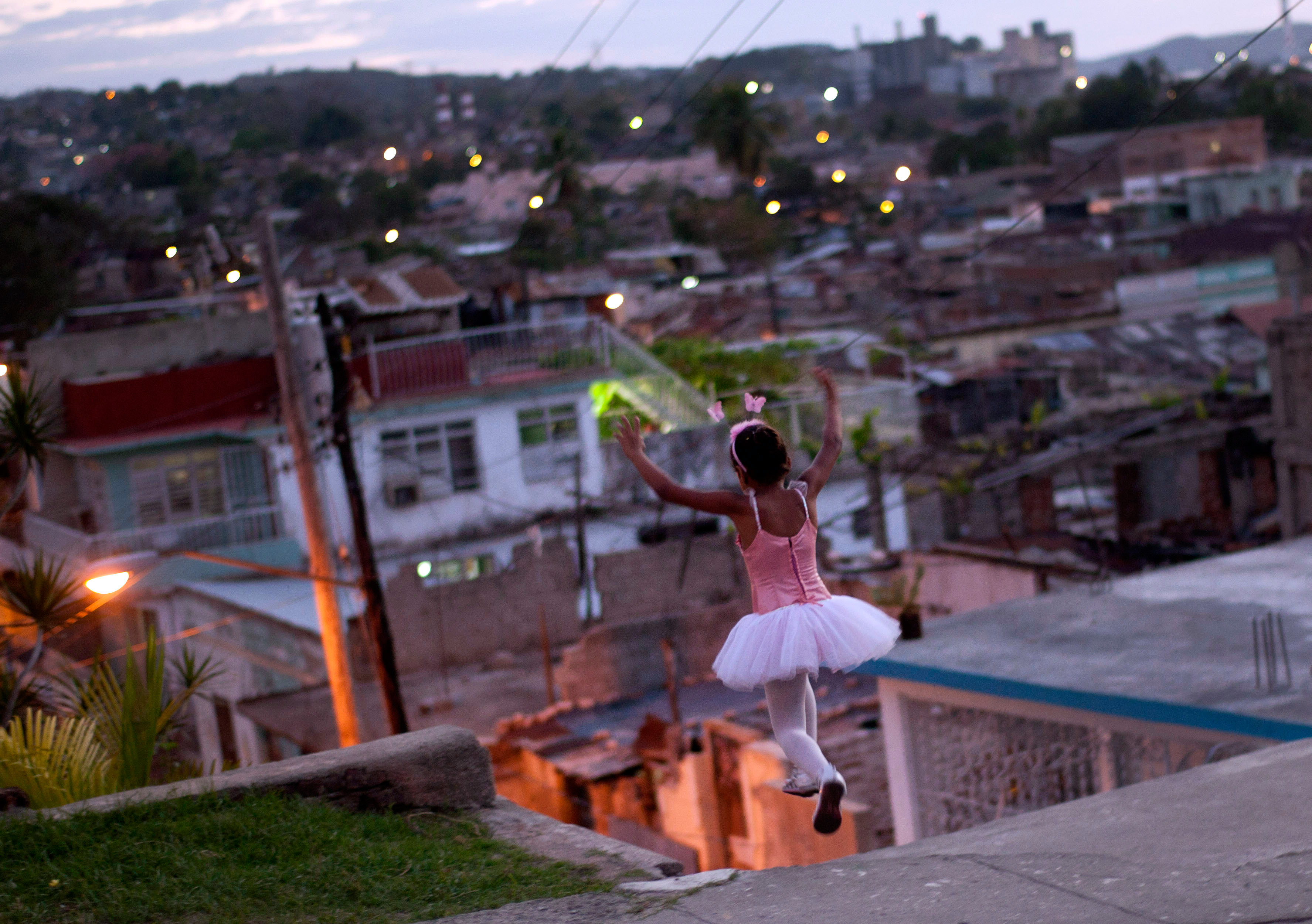 March 25, 2012. A girl wearing a ballet dress plays on the street in Santiago de Cuba, Cuba.