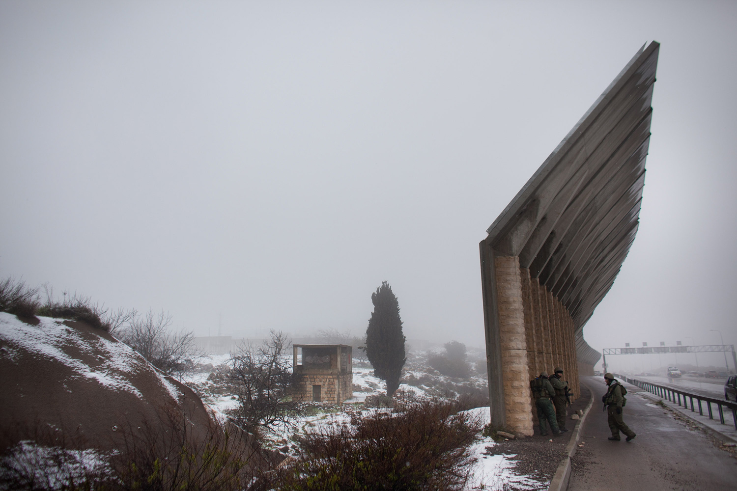 March 2, 2012. Israeli soldiers stand guard near Israel's separation barrier as snow falls near Hebron, West Bank.