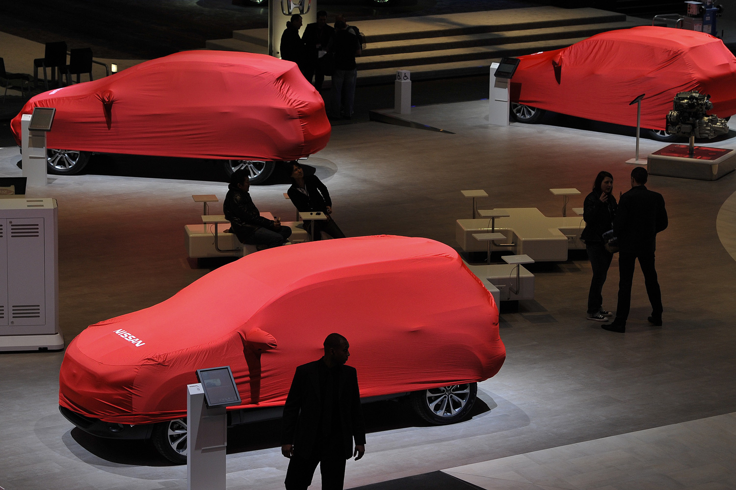 March 5, 2012. A car waits to be unveiled at the Japanese car maker Nissan's booth ahead of the 82nd Geneva Car Show in Geneva.