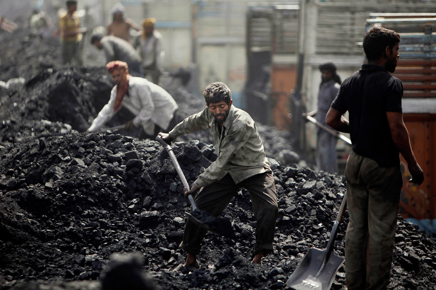 March 23, 2012. Indian laborers load coal onto trucks at a coal depot on the outskirts of Jammu, India.
