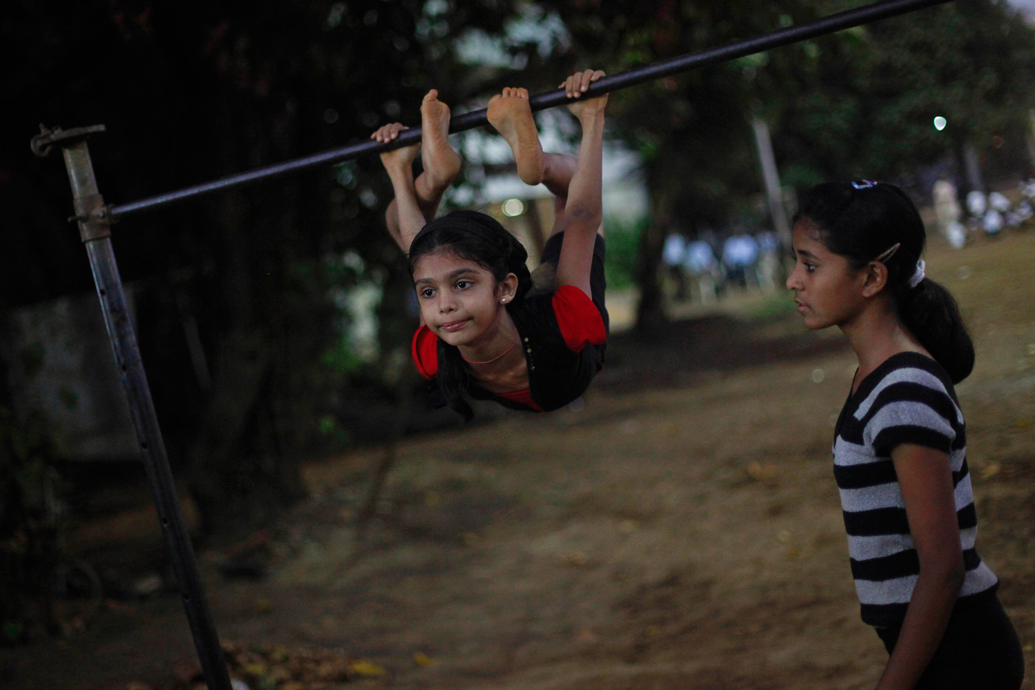 March 27, 2012. A girl exercises on a high bar during a gymnastics practice session at a park in Mumbai.