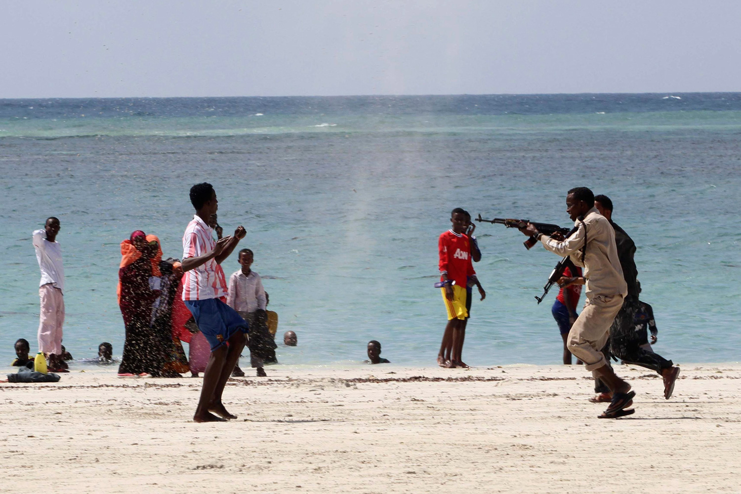 March 23, 2012. A Somali police officer, right, arrests a suspected rebel member of the Al Qaeda-affiliated al-Shabaab, left, among beach goers at the Lido beach north of Somalia's capital Mogadishu.