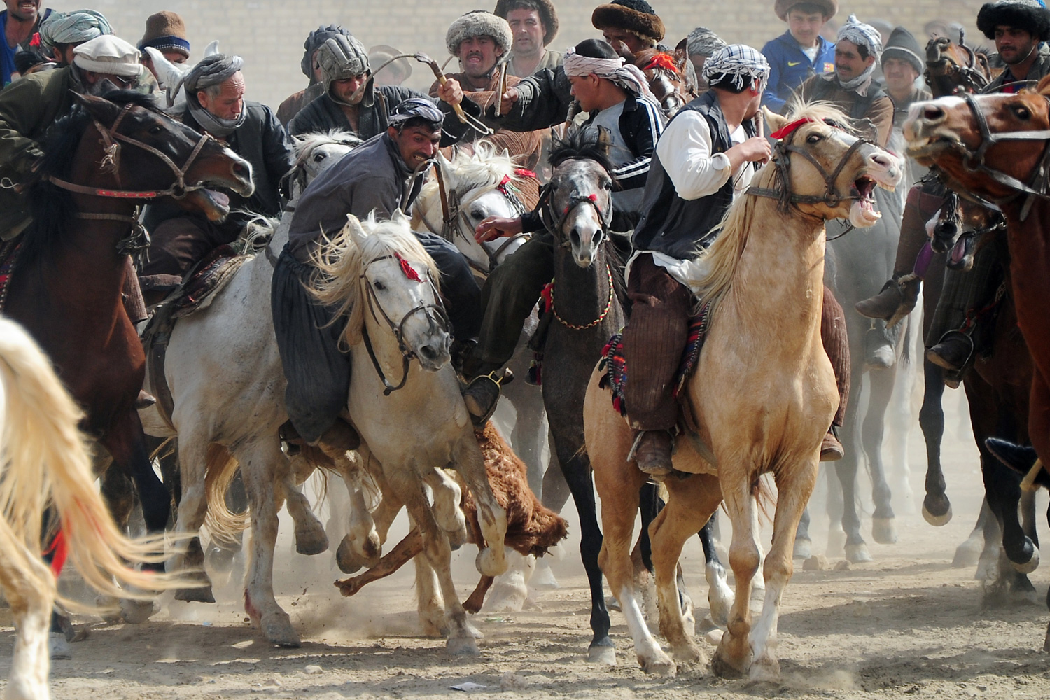 March 23, 2012. Afghan men compete with horses during the traditional Afghan sport Buzkashi in Mazar-i Sharif, Afghanistan.