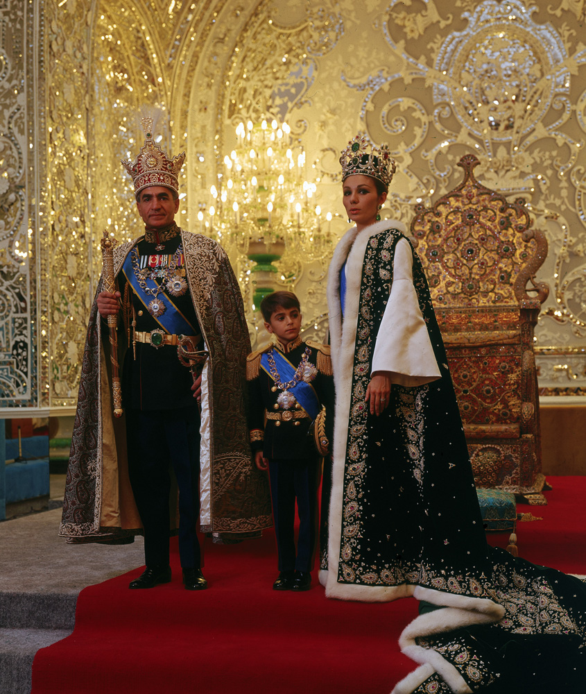 Shah of Iran, Mohammad Shah Pahlavi, posing with his son Prince Reza and wife Farah, wearing crown jewels and embroidered robes, following his coronation in 1967.