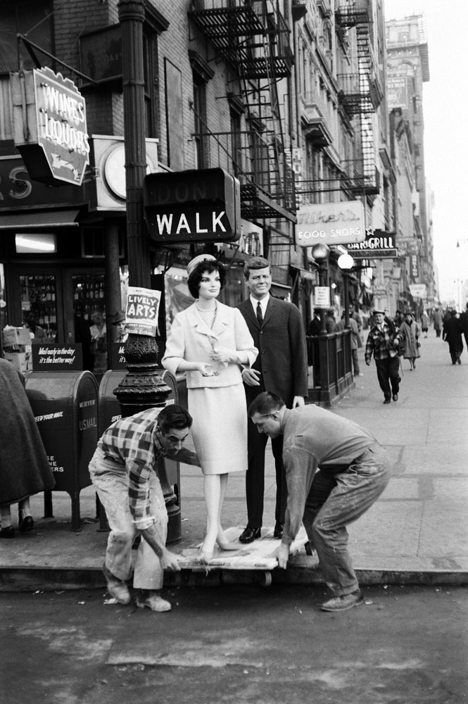 Jackie and John Kennedy mannequins draw stares on their way to store windows, New York, 1961.