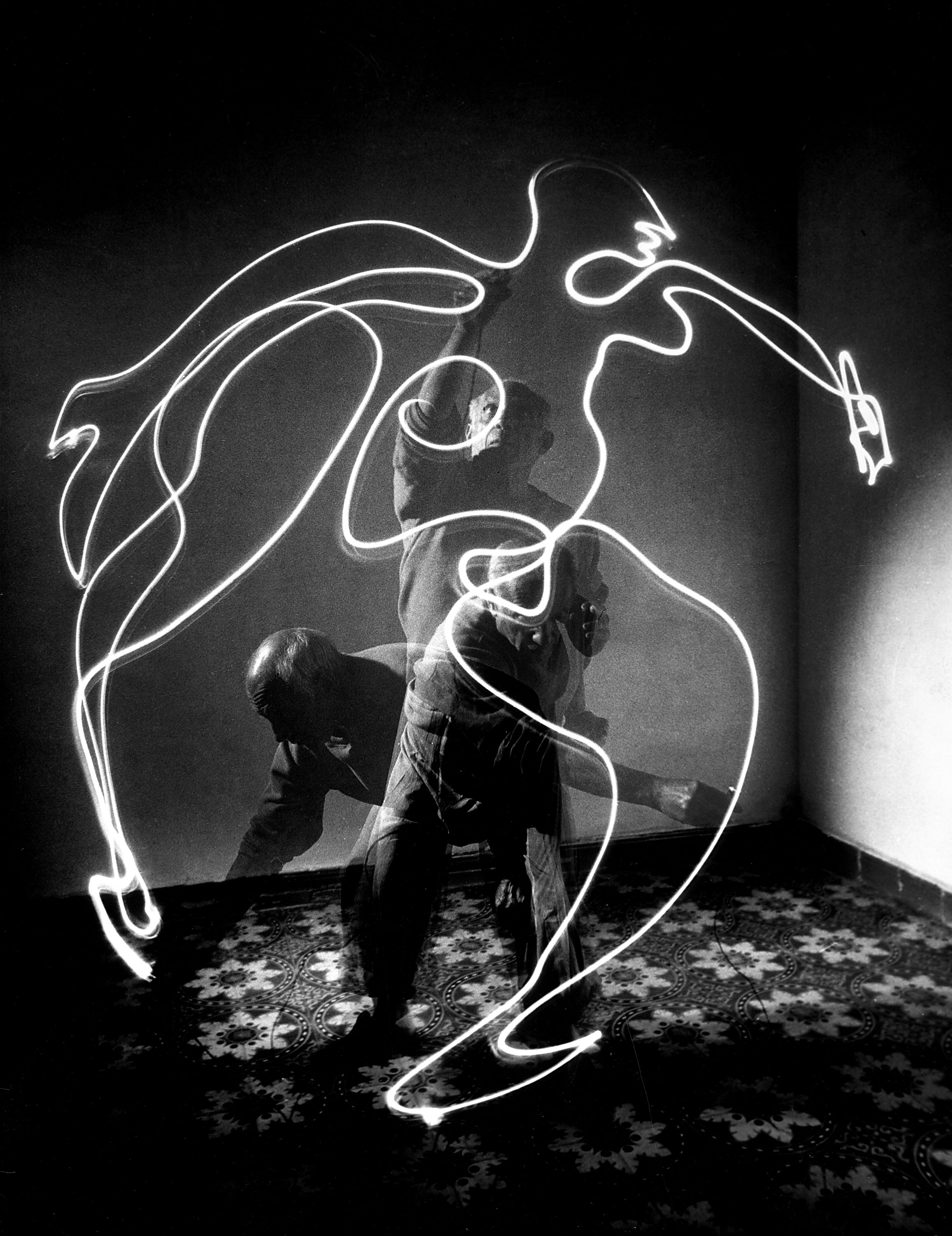 Multiple exposure photograph of Pablo Picasso using a small flashlight to "draw" a figure in the air in 1949.
