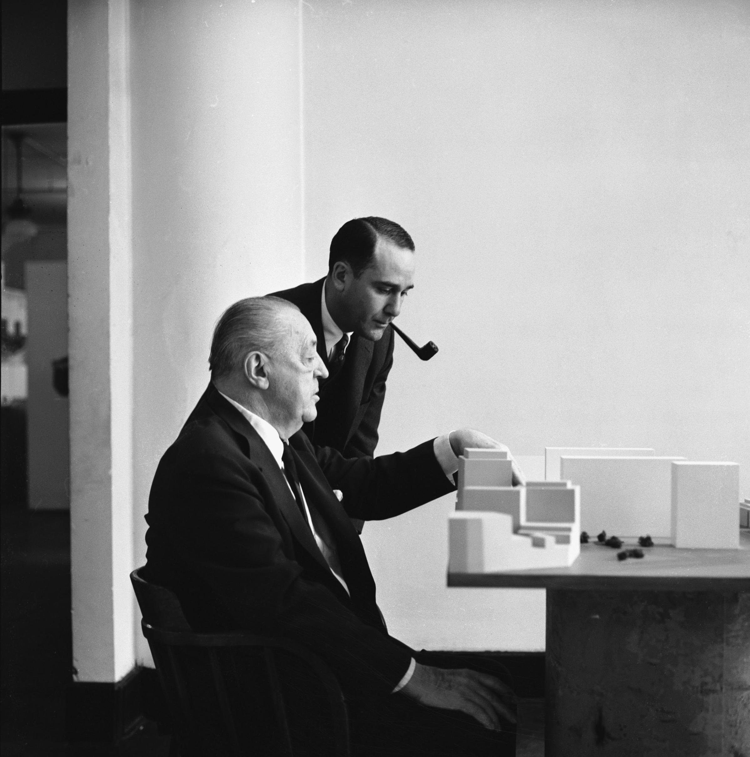 Realtor Herbert Greenwald and architect Mies van der Rohe consider a model of a Mies building, 1956.
