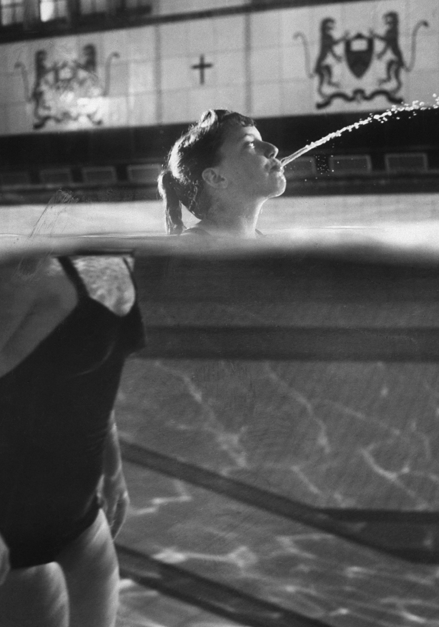 Swimmer Kathy Flicker spits water in a swimming pool in 1962.