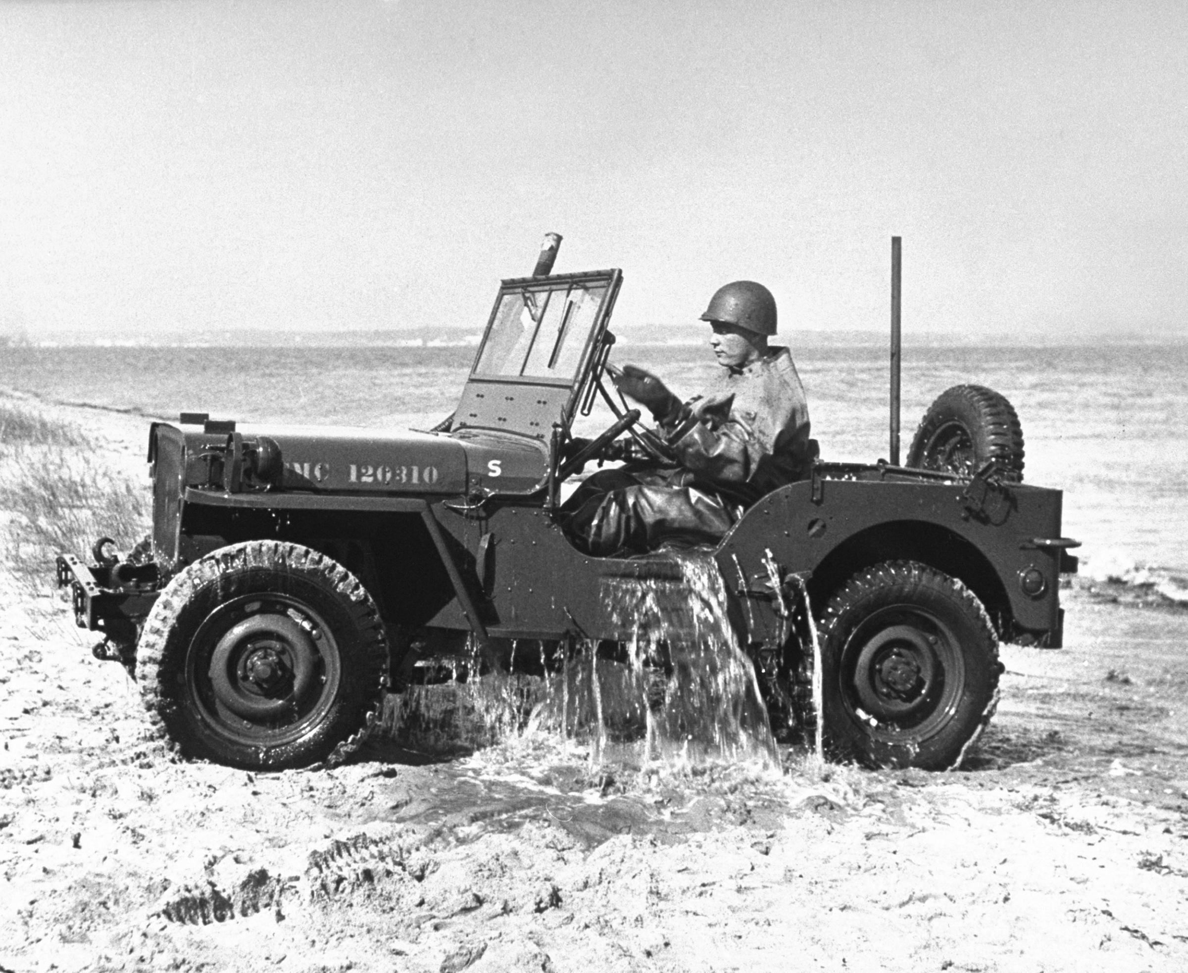 A soldier drives a Jeep out of the water in 1946.