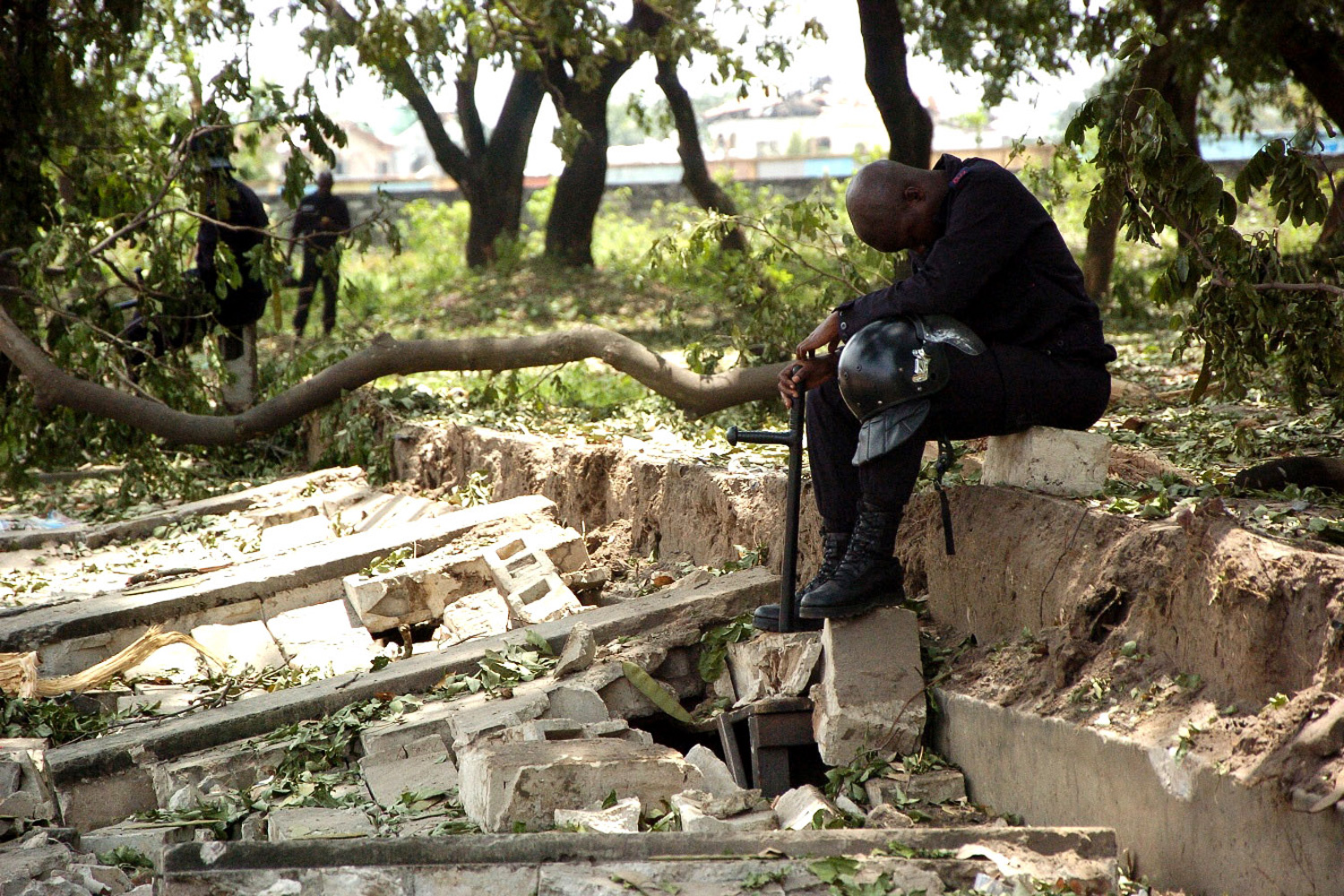 March 5, 2012. A policeman rests in the shade amongst destroyed buildings in the Mpila district of Brazzaville, Congo, following an explosion.