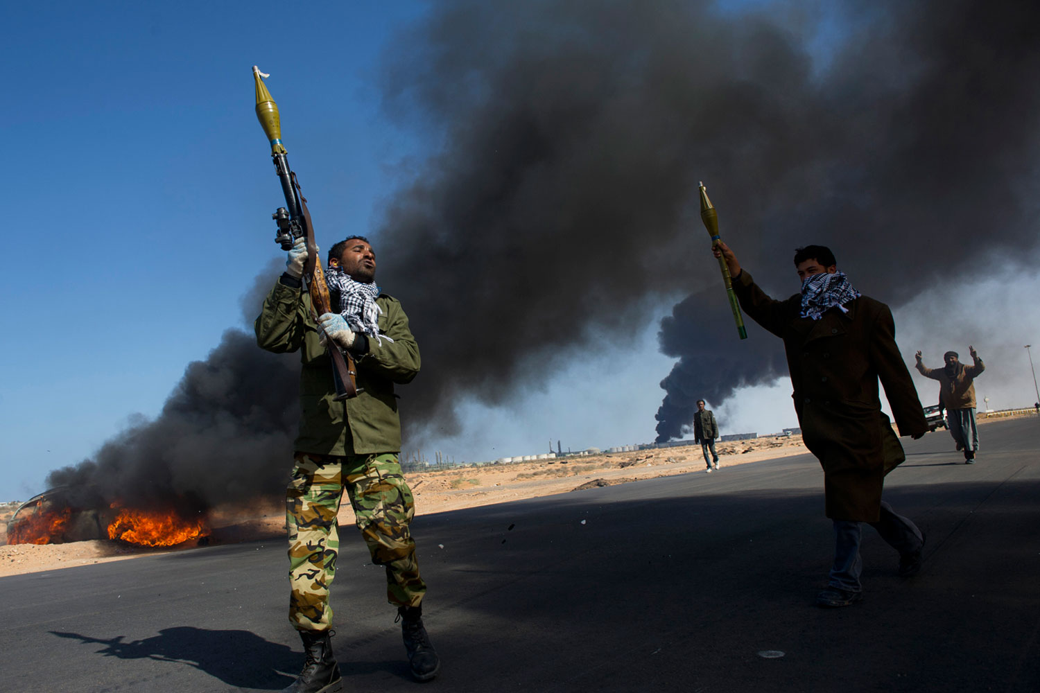 March 11, 2011. Opposition troops burn tires to use as cover during heavy fighting, shelling and airstrikes near the main checkpoint near a refinery as rebel troops pull back from Ras Lanuf, in Eastern Libya.