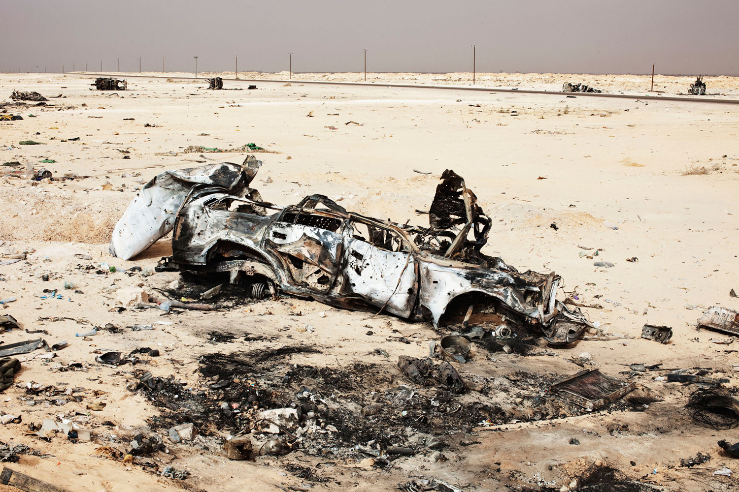 March 30, 2011. Vehicles destroyed by Western air strikes lie along the coastal highway outside Ajdabiyah in eastern Libya.