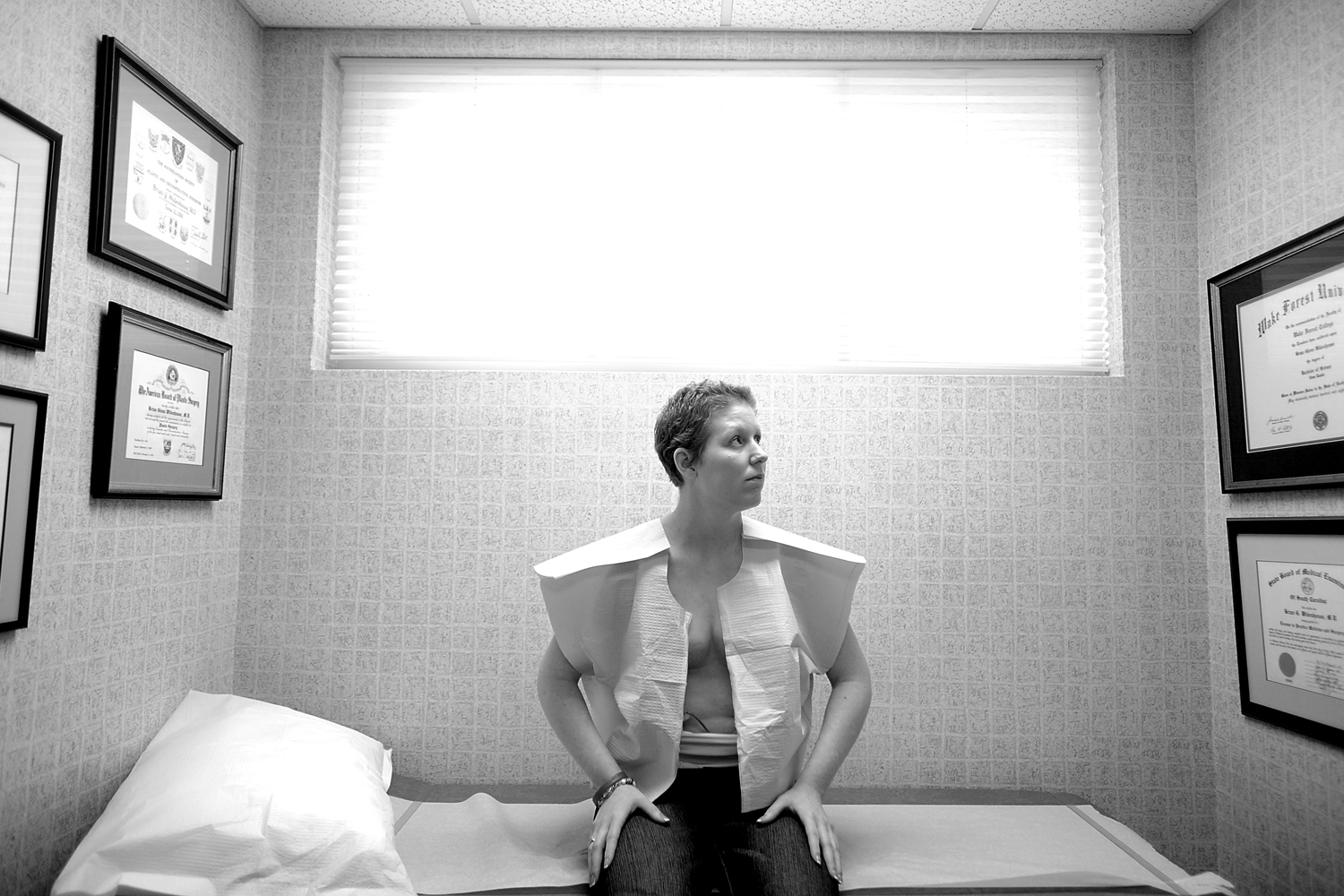 ReconstructionFirst Place, Portrait / Personality. U.S. Air Force Master Sergeant Keri Whitehead waits for a post-surgery exam at her plastic surgeon's office in Charleston, S.C. Keri underwent the first of three reconstructive surgeries after her battle with breast cancer. In the first surgery the doctors removed all of the breast tissue from Keri's left breast and then placed tissue expanders into both breast to allow stretching of the skin for future placement of breast implants. March 31, 2011.