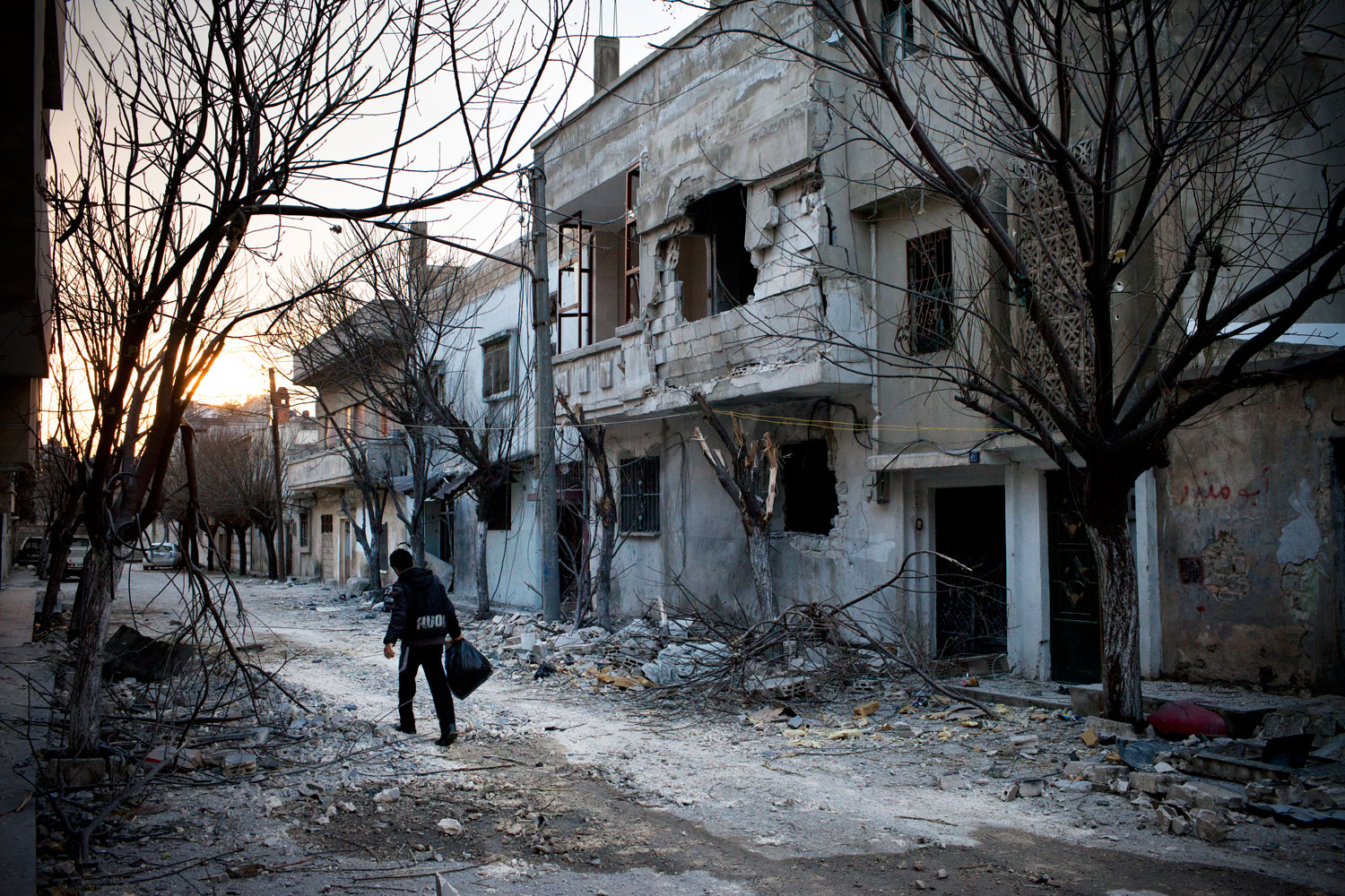 Feb. 24, 2012. A boy walks down a street in Bab Amr, Homs. The house where Daniels and three other journalists were holed up for days is behind the building at right.