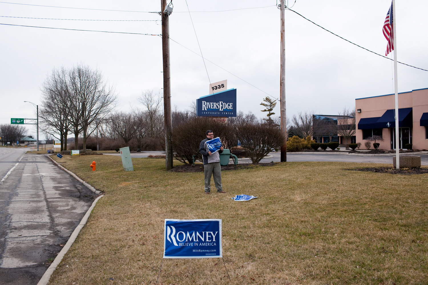 March 4, 2012. Intern Jason Rodriguez puts a yard sign in front of Mitt Romney's Columbus, Ohio, headquarters.