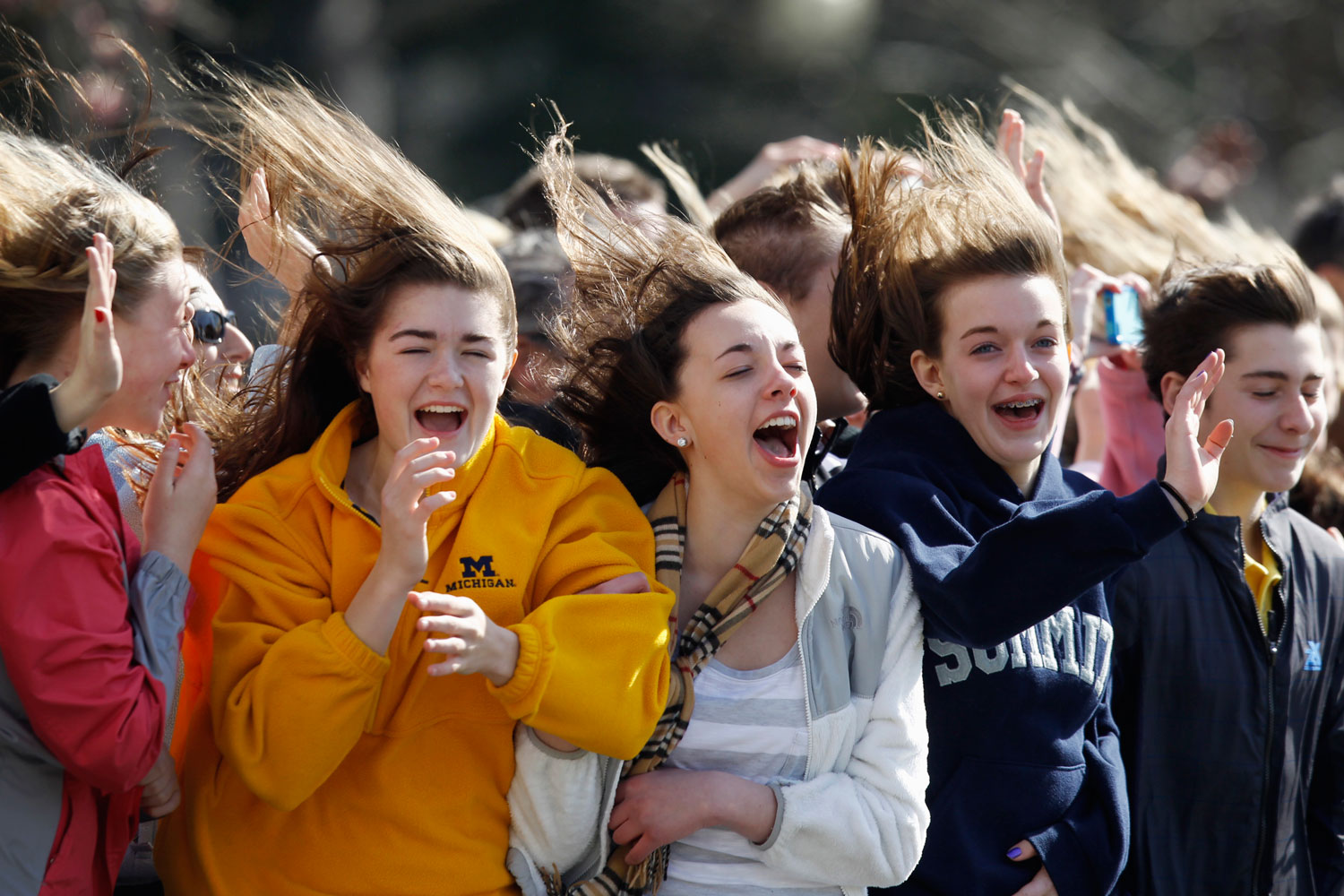 March 7, 2012. Visitors react to the rotor wash of the Marine One helicopter as President Barack Obama takes off from the South Lawn of the White House in Washington as he travels to North Carolina.