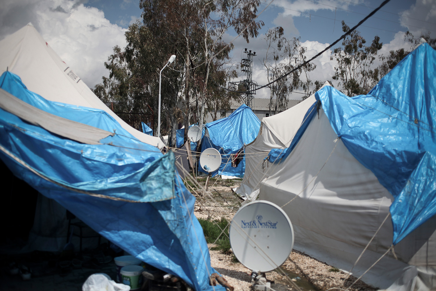 March 29, 2012. Satellite dishes are seen outside of tents at an old cigar factory that was converted into a Syrian refugee camp near Antakya in southern Turkey near the border with Syria.