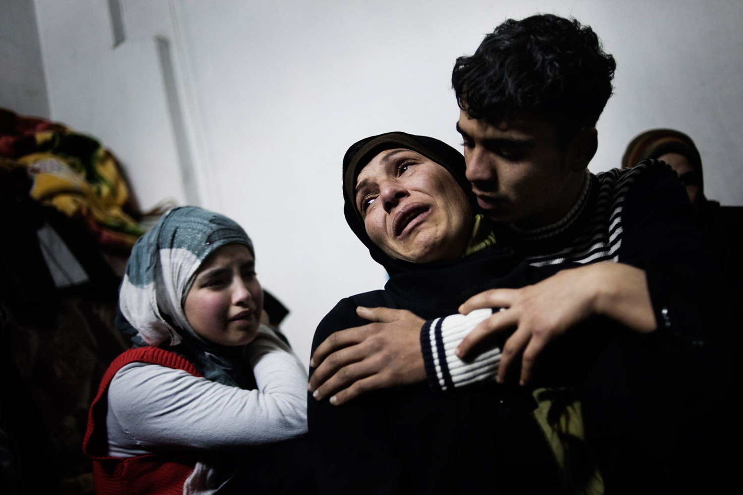 Feb. 20, 2012. A mother and her children cry over the loss of her other two sons, killed by a mortar attack launched by Al Assad forces, in Homs province.