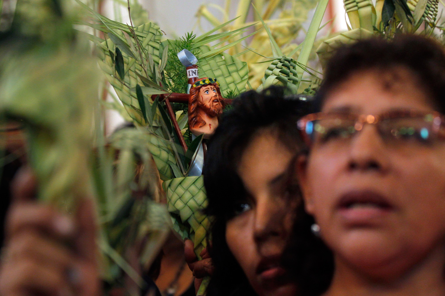 April 1, 2012. Women pray as they attend Palm Sunday Mass at the cathedral in Lima.