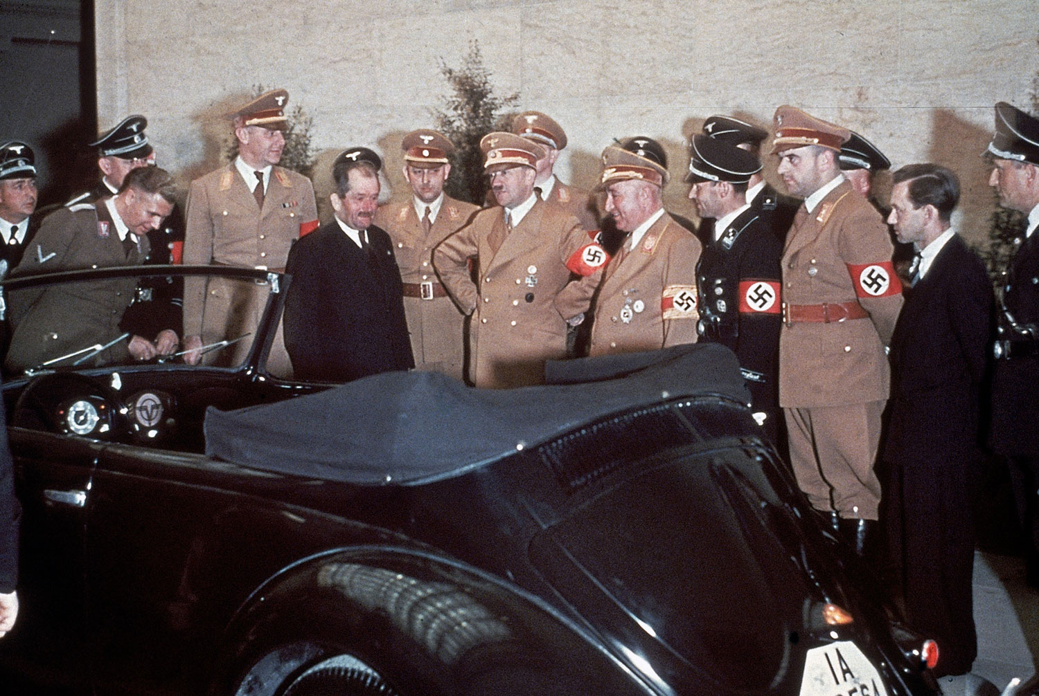 The automobile engineer Ferdinand Porsche (in suit), Adolf Hitler and, immediately to Hitler's left, the head of the German Labour Front, Robert Ley, admire Hitler's birthday gift on his 50th birthday: a convertible Volkswagen.