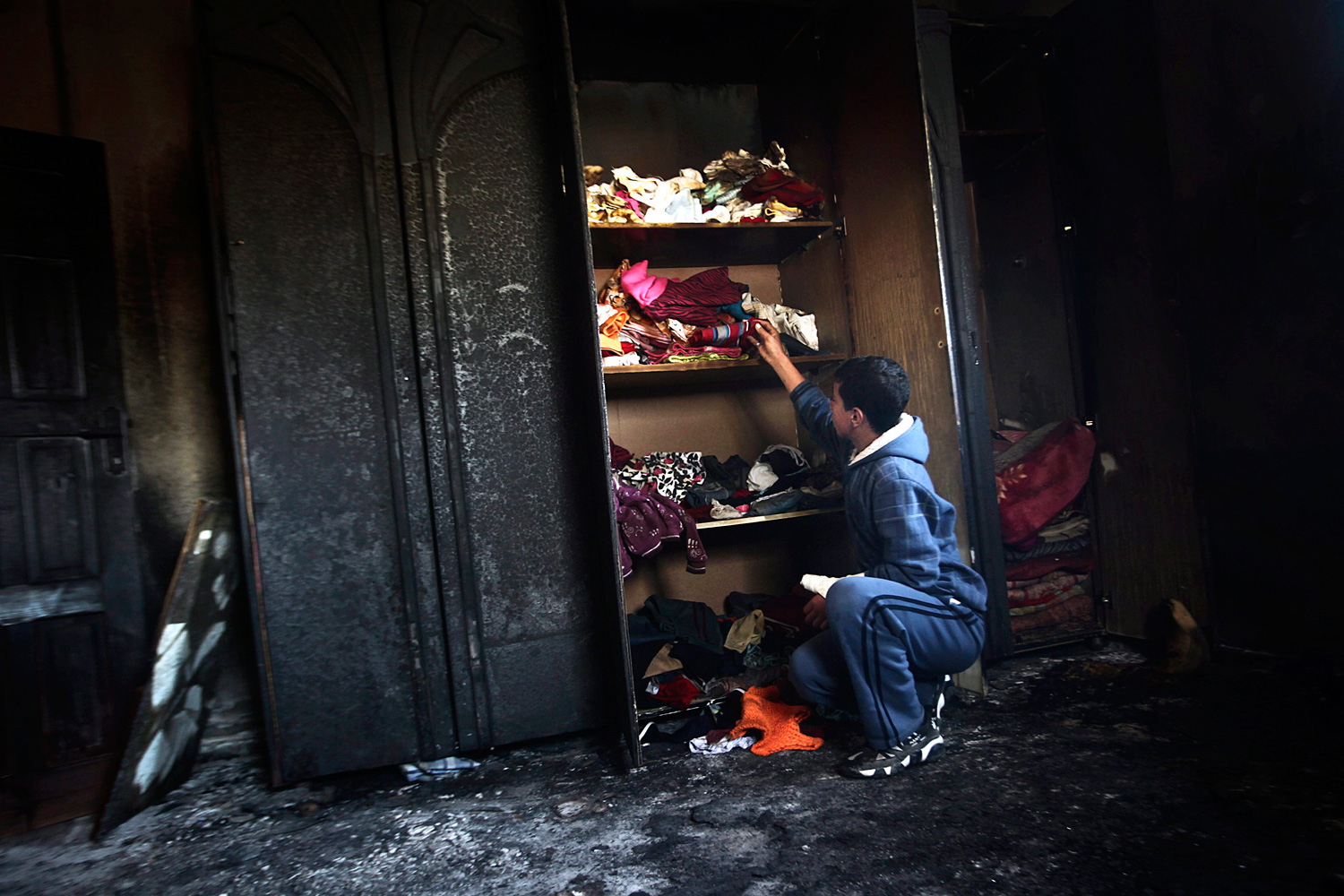 April 2, 2012. A Palestinian youth from the Bashir family inspects the rubble in the room of the three children who were killed in Deir al-Balah in the central Gaza Strip.