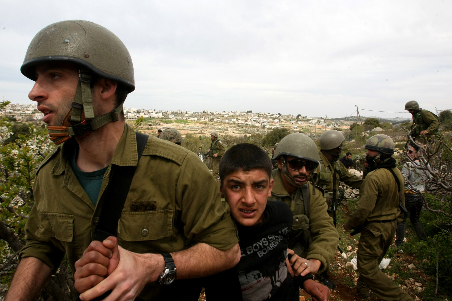 March 31, 2012. A Palestinian boy is detained by Israeli soldiers during a demonstration against the occupation of their village land and the building of the Israeli settlement of Karmei Tzour near the village of Beit Omar, north of the West Bank town of Hebron.