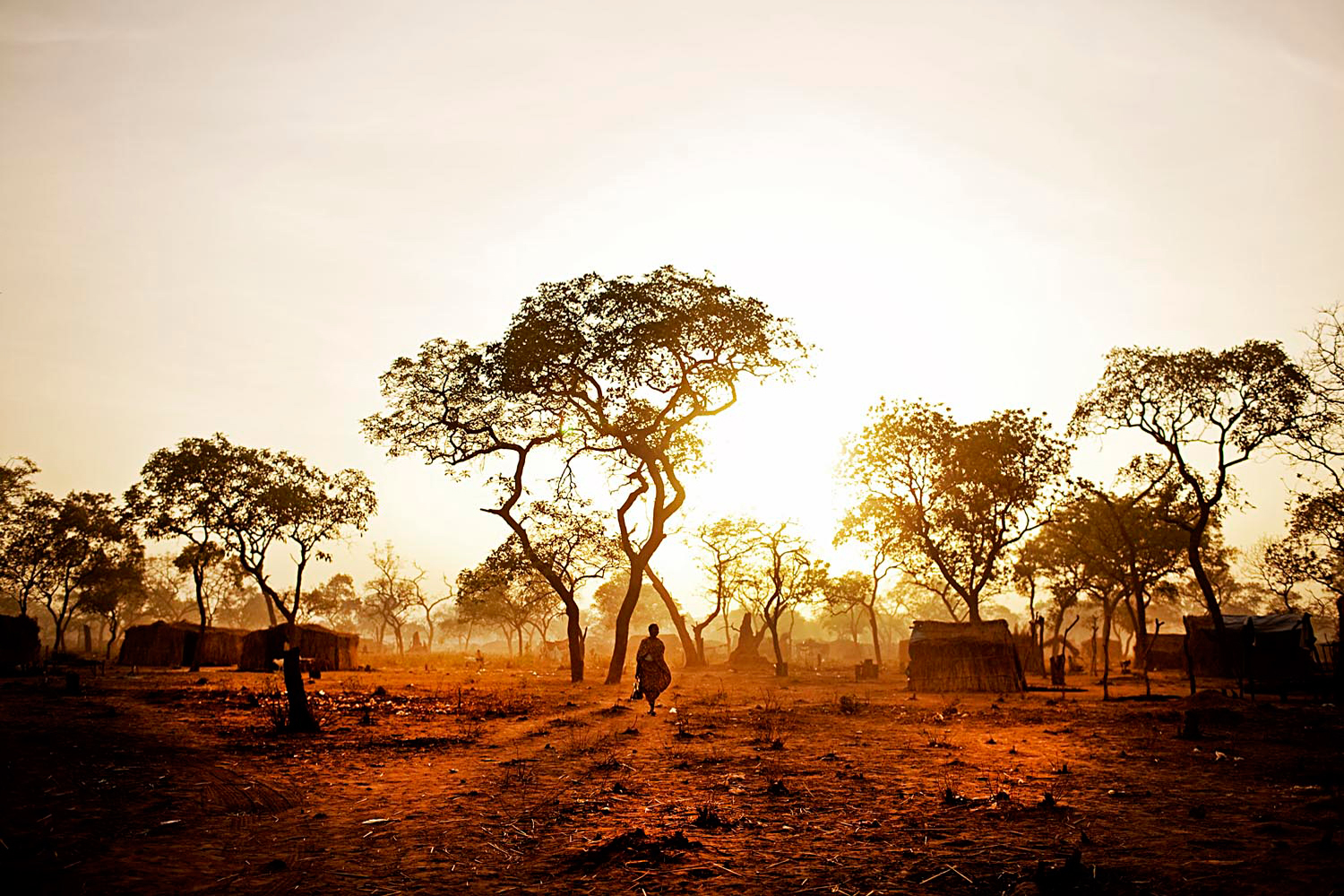 A refugee from the Nuba Mountains wanders through the Yida refugee camp at dawn. People try to accomplish tasks early in the day before the heat sets in.