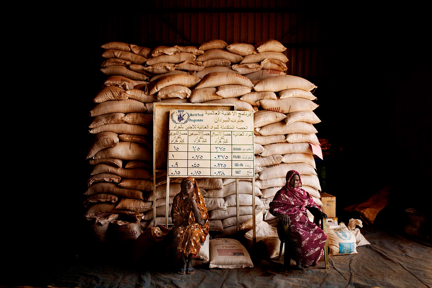 Nuba women sit inside a food storage warehouse in the Yida refugee camp. Food shortages are extreme among refugees fleeing violence in South Kordofan.