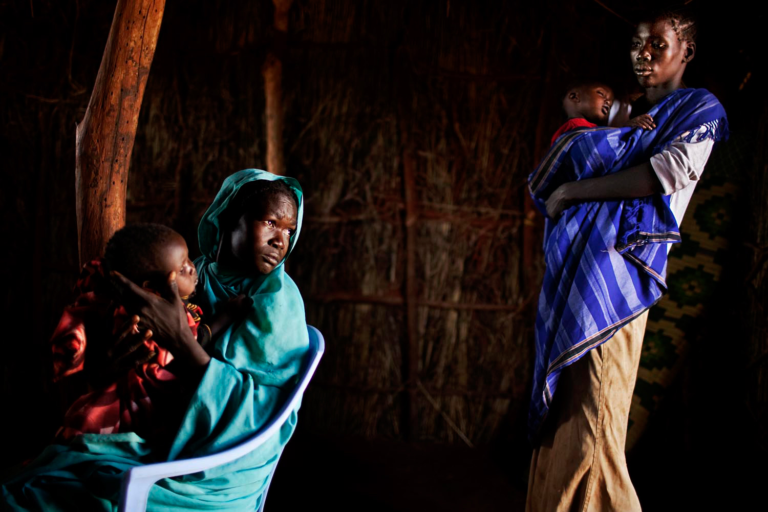 Nuba women wait to have their children examined at a clinic.