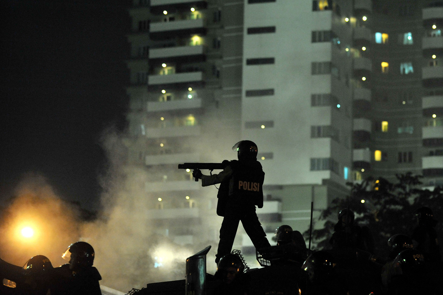 March 30, 2012. An Indonesian policeman fires tear gas during a clash between police and protesters at a rally against the government's plan to hike fuel prices in Jakarta.