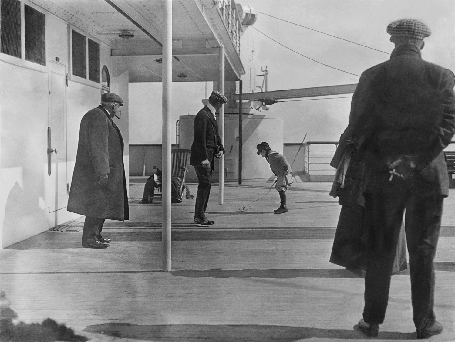 In a photograph taken by an Irish Jesuit, Father Francis Browne, aboard the Titanic, six-year-old Robert Douglas Spedden, plays with a spinning top while his father, Frederic, looks on.