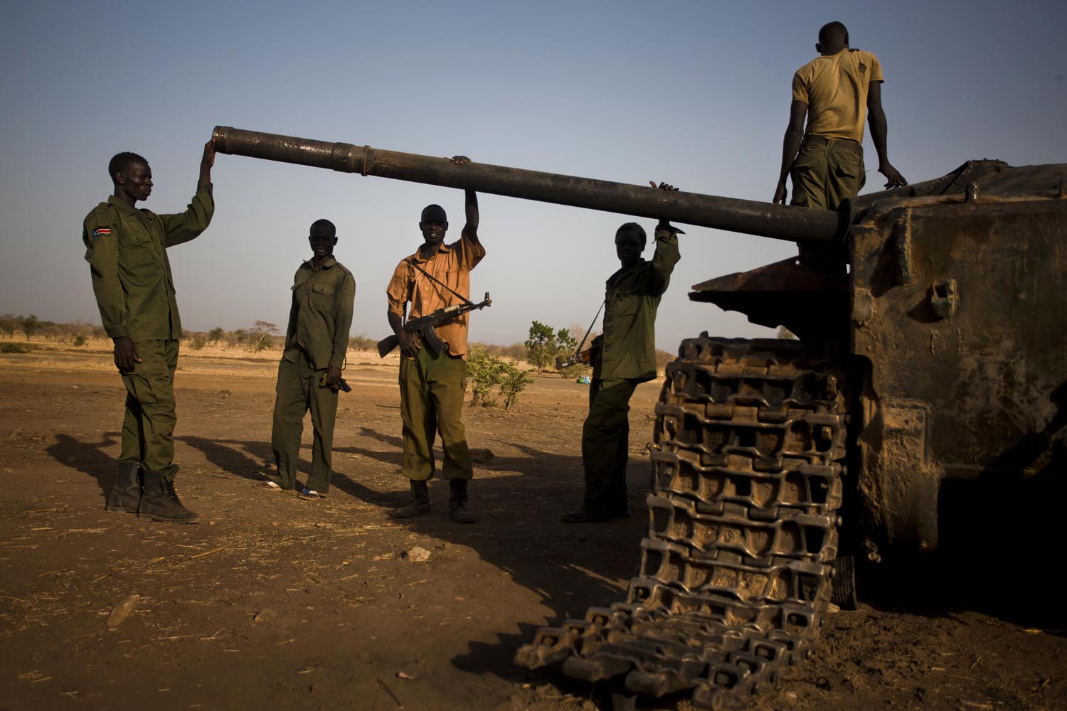SPLA-North soldiers stand next to a destroyed SAF tank.