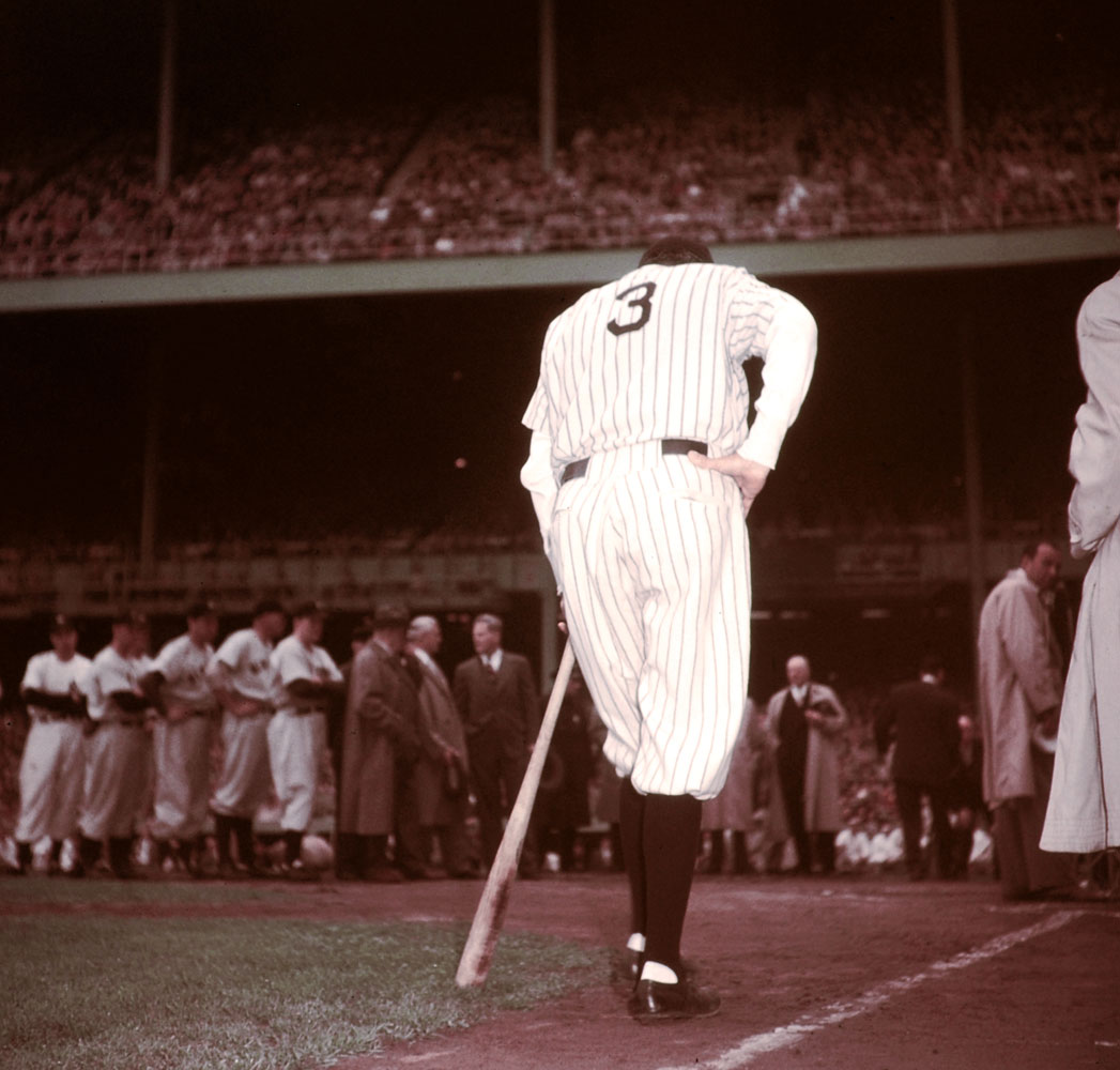 Leaning on a bat for support, Babe Ruth waits to speak at Yankee Stadium, June 13, 1948, the day the Bombers retired his famous No. 3.