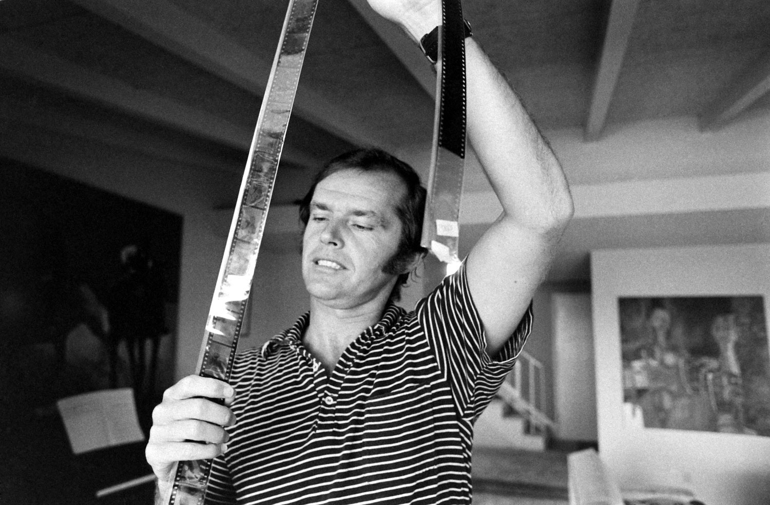 Jack Nicholson looks at film negatives at his home, Los Angeles, 1969.