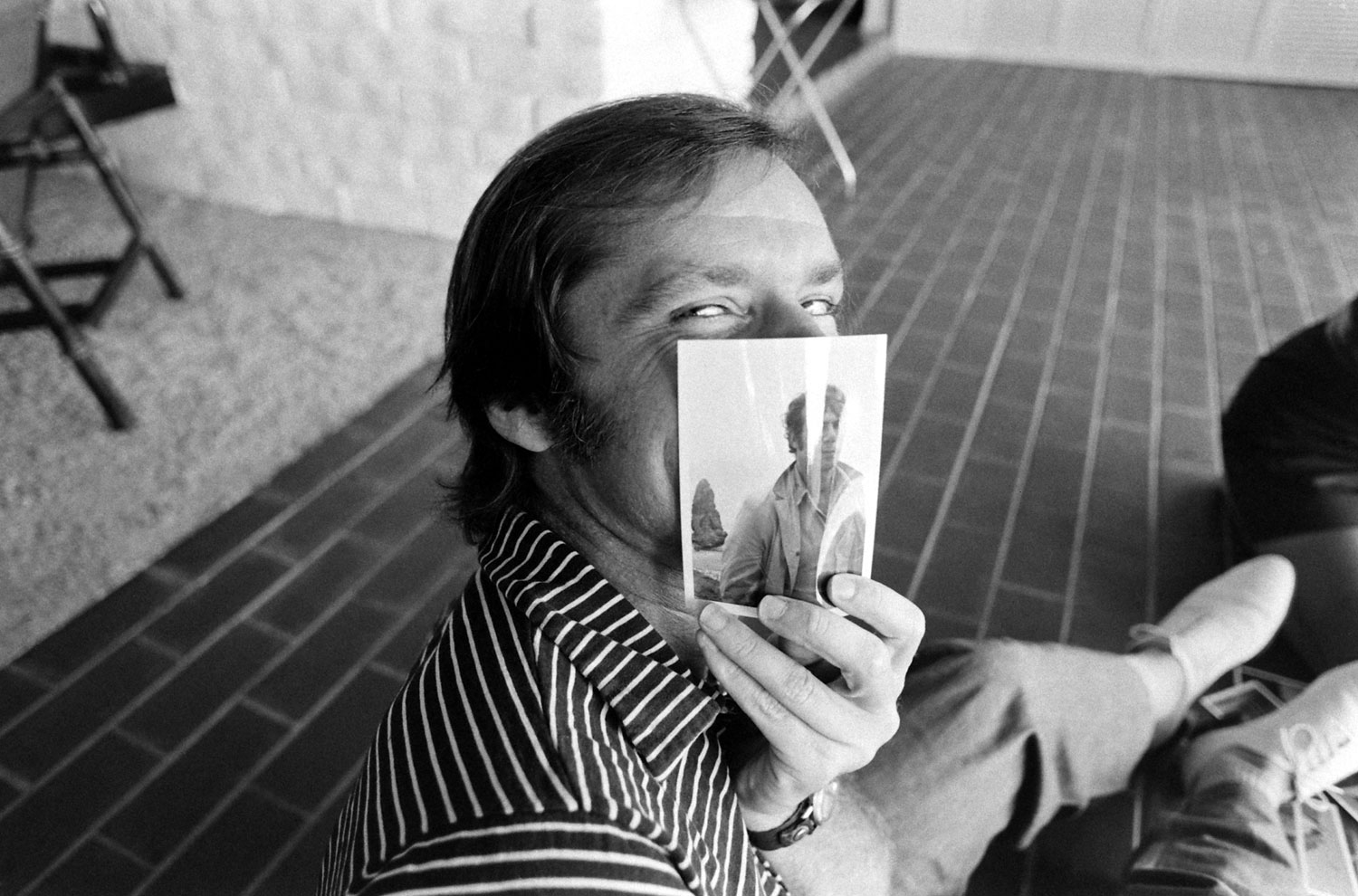 Jack Nicholson clowns around at his home with a picture of his friend, the film director Bob Rafelson, Los Angeles, 1969.