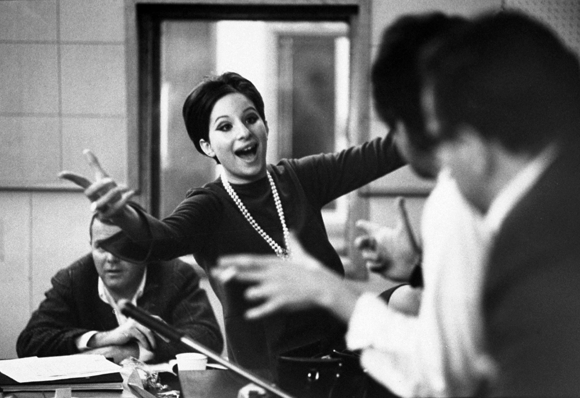 Barbra Streisand in a recording studio in 1966, listening to herself sing.