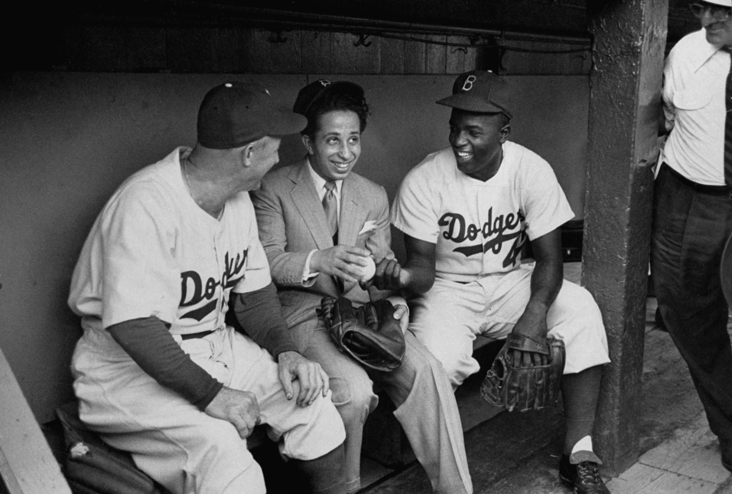 Jackie Robinson, Brooklyn manager Charlie Dressen and Iraq's King Faisal II chat in the dugout in 1952.