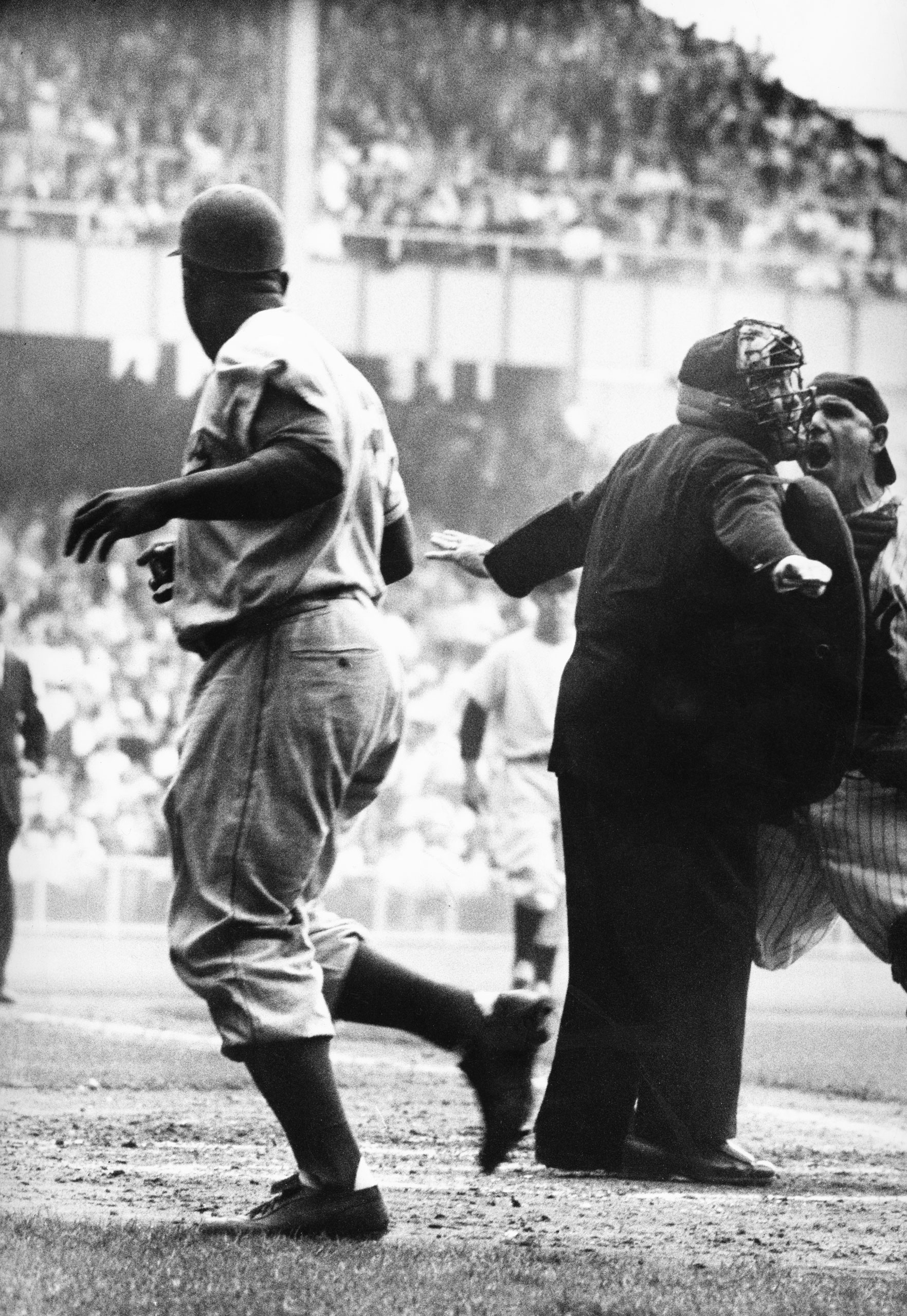 Yogi Berra takes issue with the umpire's "safe" call after Jackie Robinson's electrifying steal of home in Game 1 of the 1955 World Series.