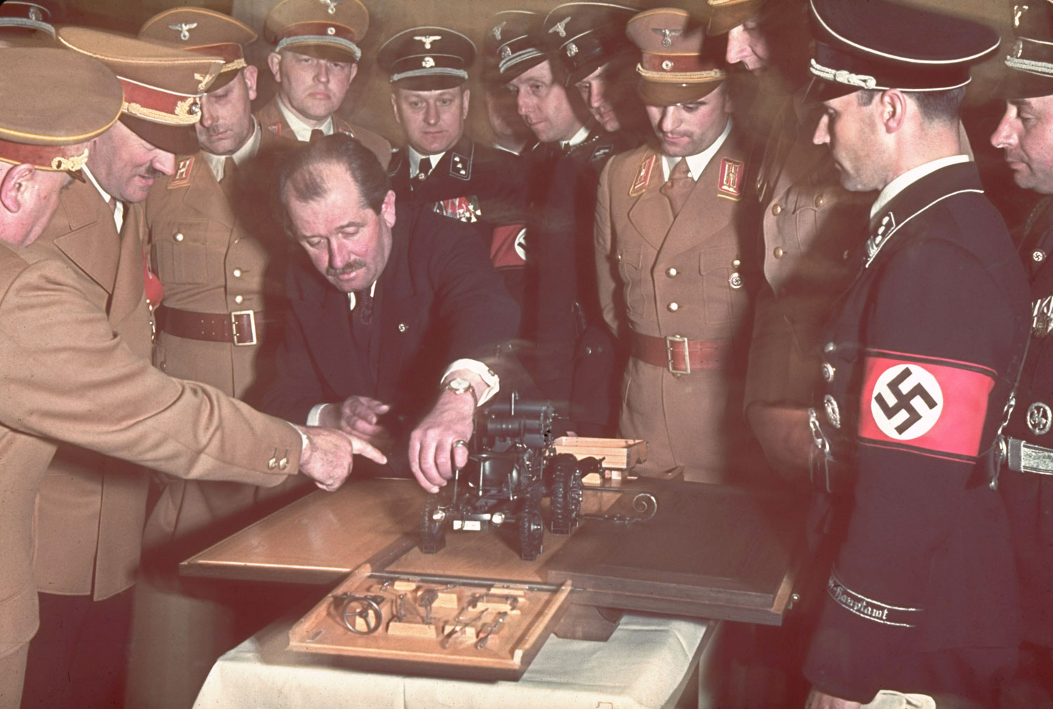 The automobile engineer and designer Ferdinand Porsche (in suit) presents Adolf Hitler with a model car during celebrations for Hitler's 50th birthday, Berlin, April 1939.