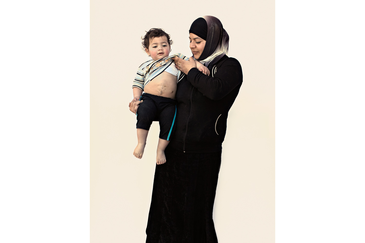 Fadia al-Abdo, 27, with her year-old son Mohammad Dali“My son had a hernia and needed to be operated on [in Syria]. I left him for just a minute, and that’s when the soldiers came into the hospital. By the time I got back to my son’s room, his insides were outside his body. He has had four operations so far. They say a small bullet or shrapnel hit him, cut him open. I have spent a year
                              like this, watching him suffer. God damn Bashar.”