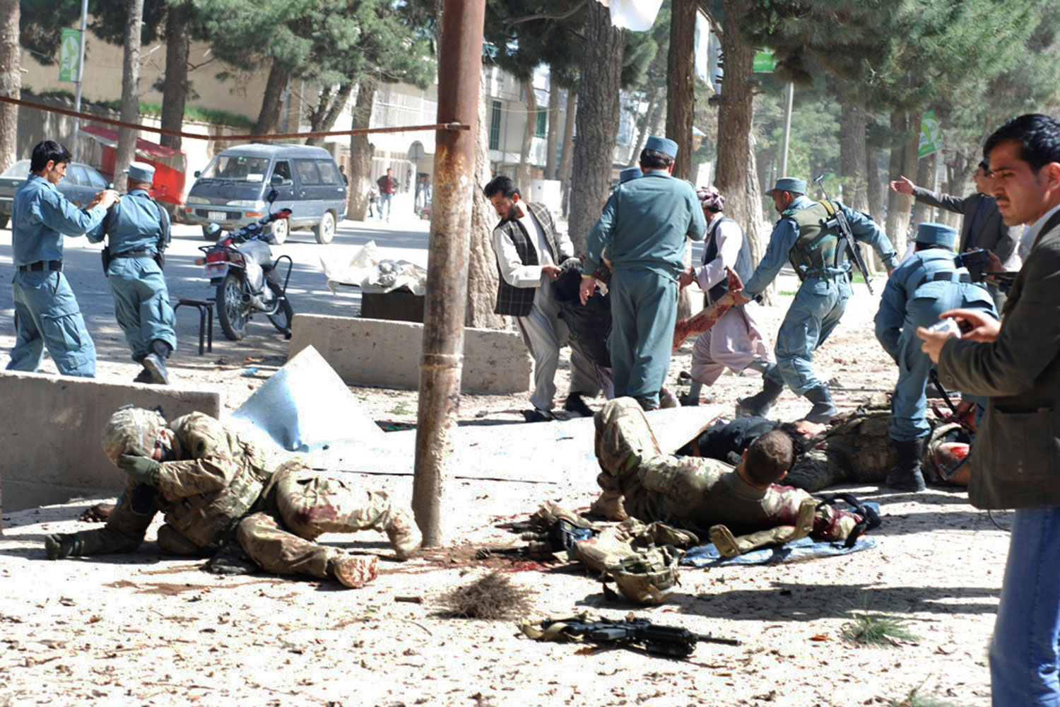 April 4, 2012. Wounded U.S. soldiers lie on the ground at the scene of a suicide attack in Maimanah, the capital of Faryab province north of Kabul, Afghanistan. A suicide bomber blew himself up, killing at least 10 people, including three NATO service members, officials said, the latest in a string of attacks as spring fighting season gets under way. A senior U.S. defense official has confirmed that two U.S. soldiers were among three NATO forces killed in a suicide bombing in northern Afghanistan.
