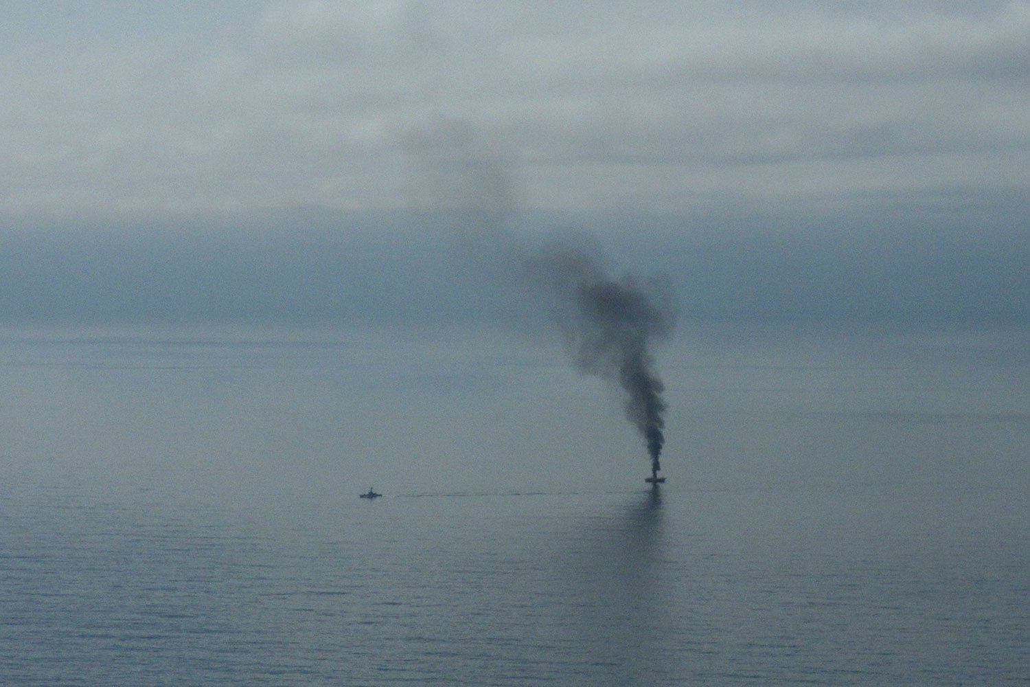 April 5, 2012. A giant plume of smoke rises from a derelict Japanese ship after it was hit by canon fire by a U.S. Coast Guard cutter in the Gulf of Alaska. The Coast Guard decided to sink the ship dislodged by last year's tsunami because it was a threat to maritime traffic and could have an environmental impact if it grounded.