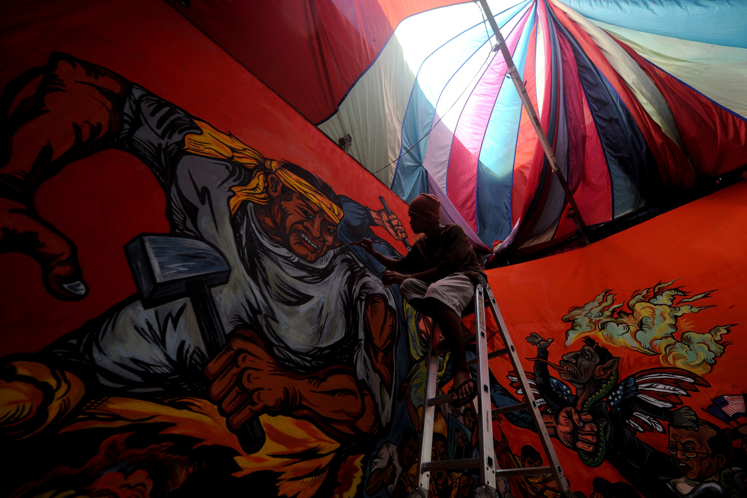 April 29, 2012. Filipino activists apply the finishing touches to a mural that will be used on Labor Day at their headquarters in Quezon City, east of Manila, Philippines.
